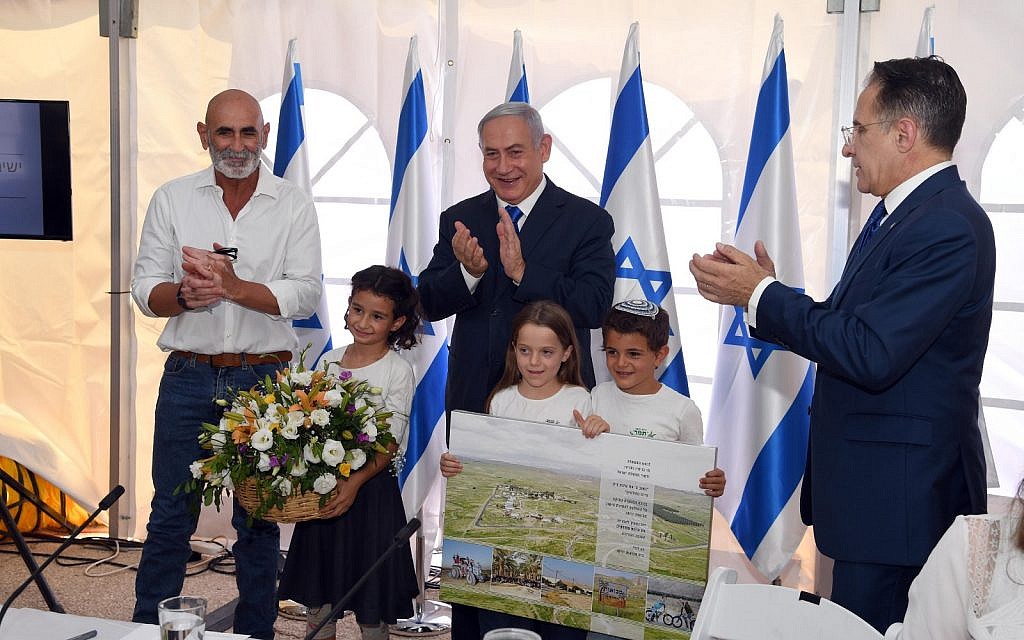 (From L-R) Jordan Valley Regional Council chairman David Elhayani, Prime Minister Benjamin Netanyahu and cabinet secretary Tzachi Braverman applaud after the government authorized the legalization of Mevo'ot Yericho, a West Bank settlement, at the weekly cabinet meeting at the Jordan Valley Regional Council, September 15, 2019 (Haim Tzach/GPO)